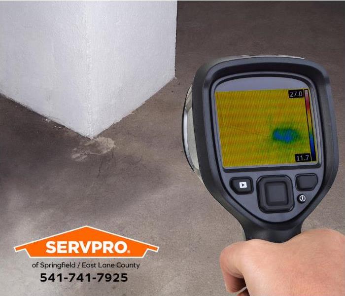 A person uses an infrared camera to locate hidden water damage.