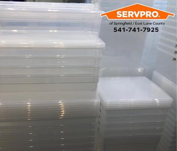 Stacks of clear plastic storage bins and lids are shown.